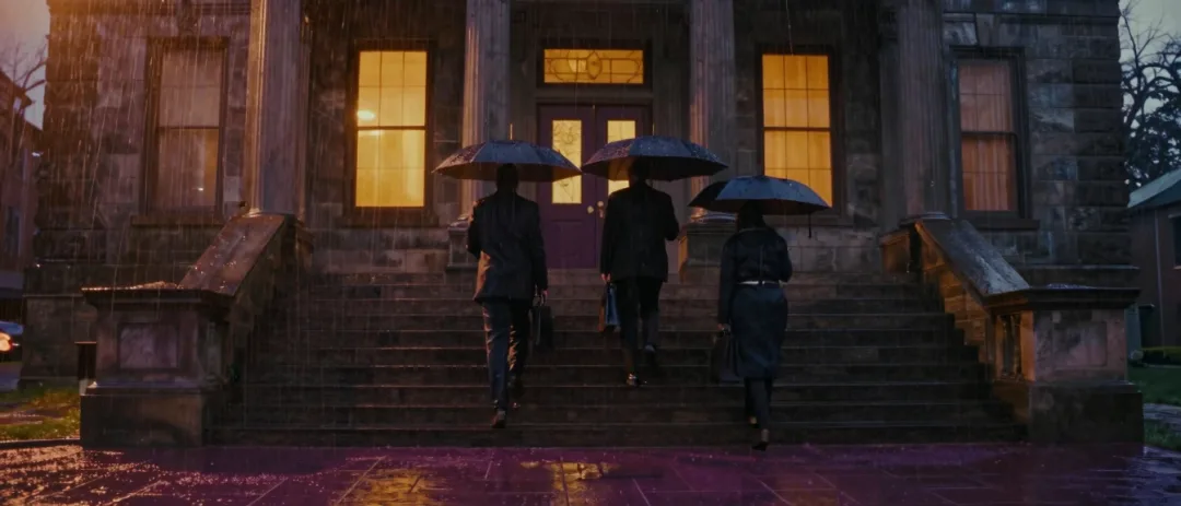 Umbrellas crossing a rainy courthouse plaza.