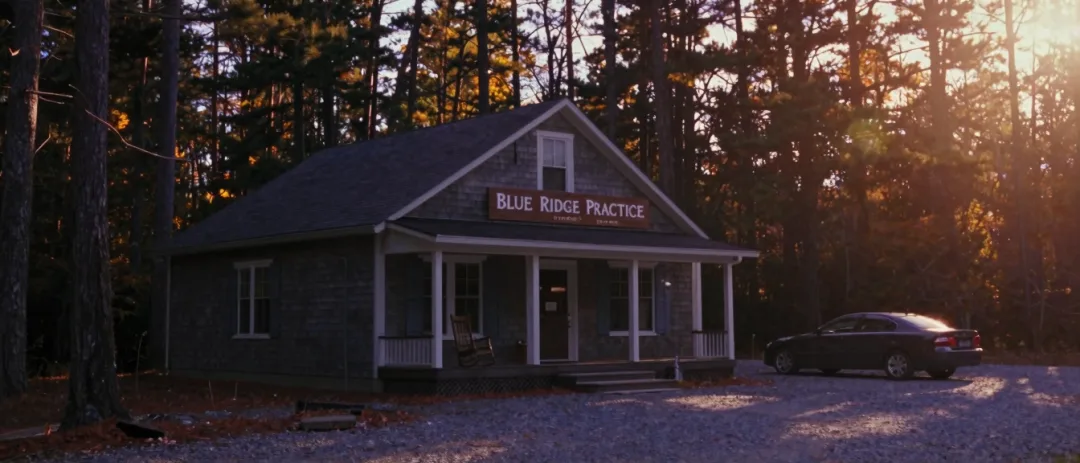 A mountain law office among pines, evening light in the windows.