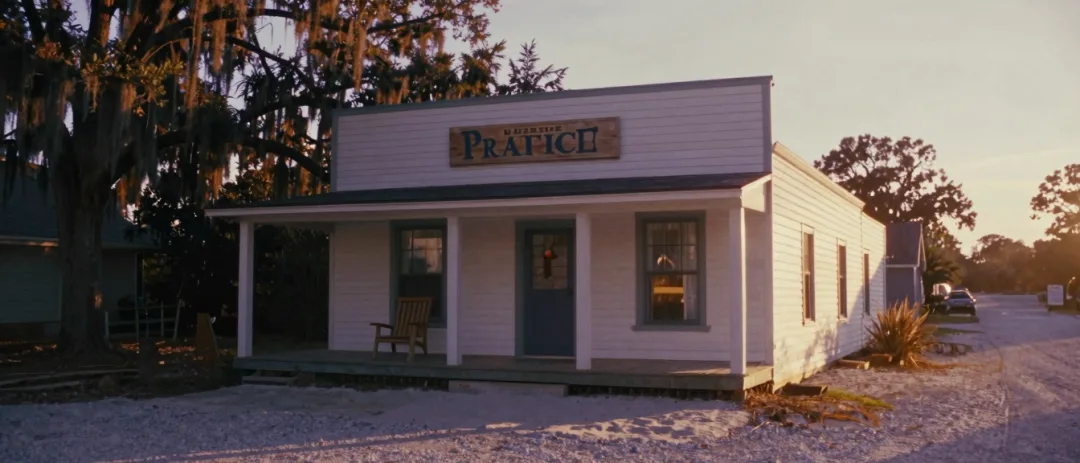 A white clapboard law office on the North Carolina coast under soft morning sun.